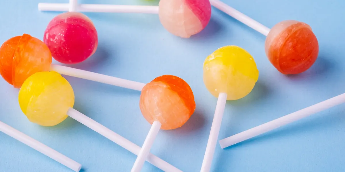 scattered lollipop candies on blue background angle view scattered lollipop candies on blue background angle view