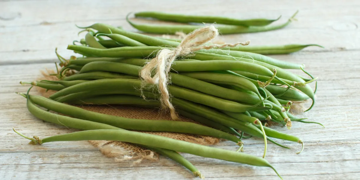 haricots verts frais sur un fond en bois