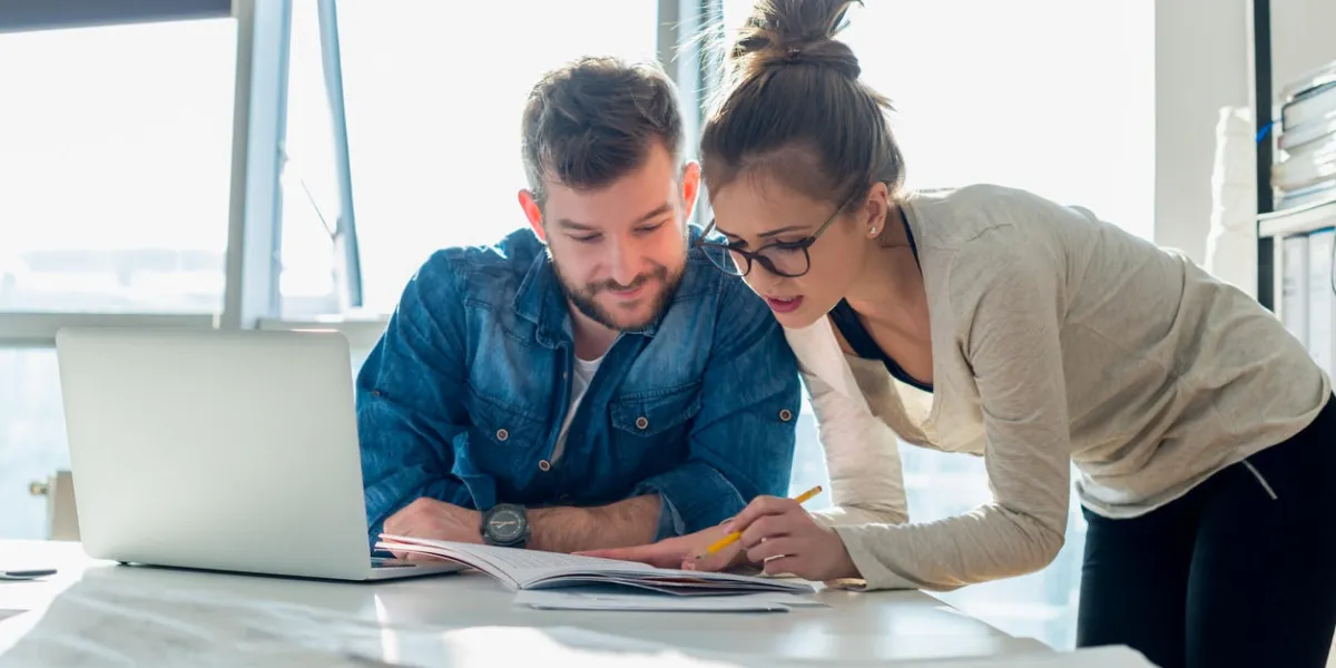deux jeunes gens regardant un document papier