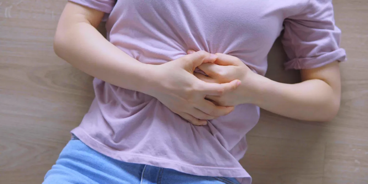 woman in home with strong stomach menstruation pain
