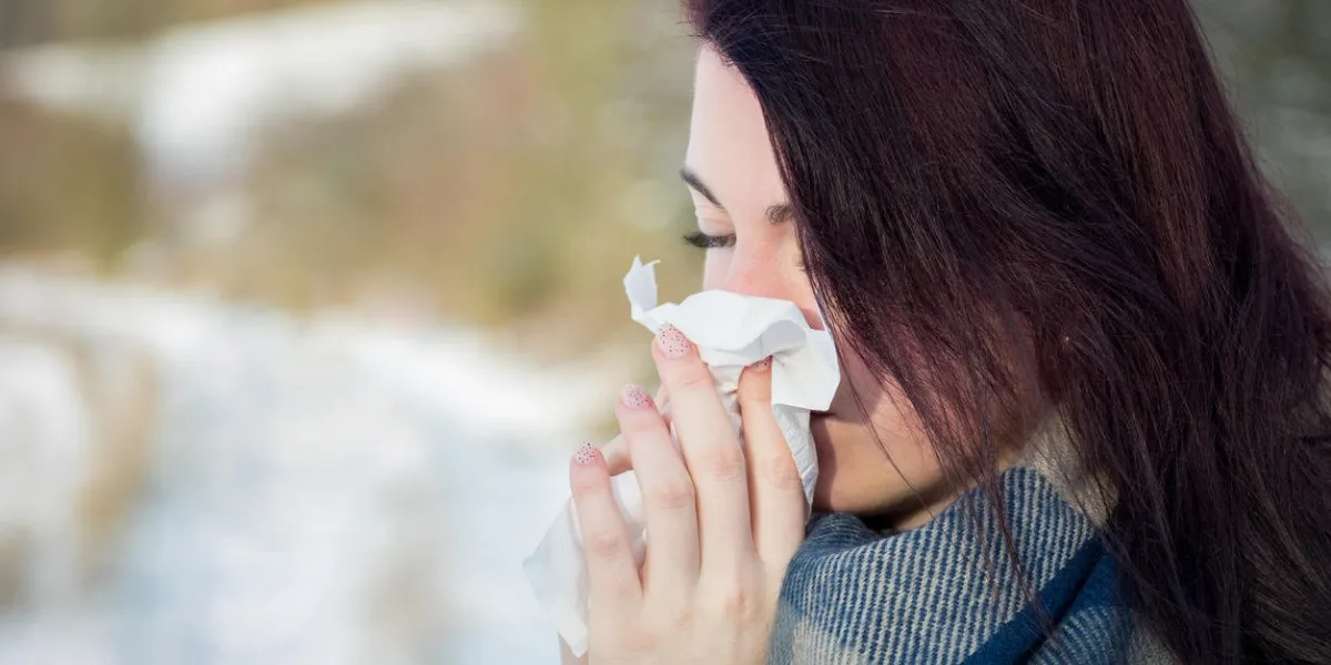 young woman suffering from cold, flue, or allergy blowing her nose young woman suffering from cold, flue, or allergy blowing her nose