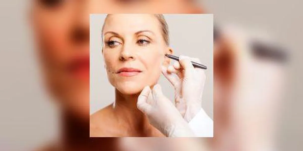 médecin dessin corrigeant les lignes sur le visage de la femme senior avant la chirurgie plastique