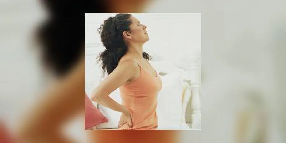 femme assise sur le lit en se tenant, les yeux fermés femme assise sur le lit en se tenant, les yeux fermés