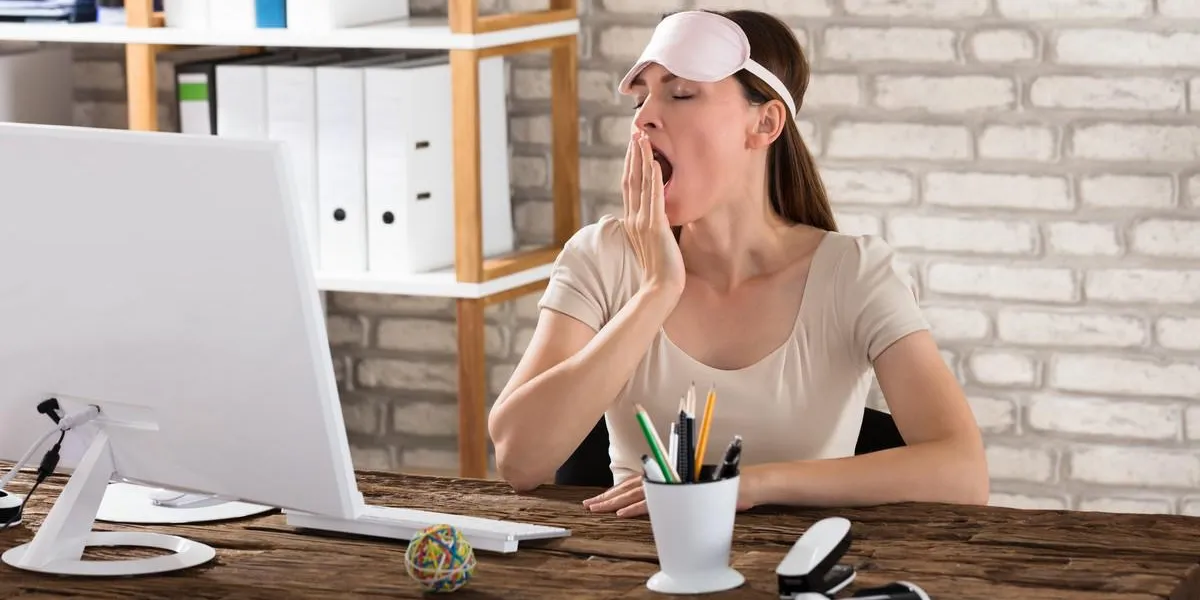 jeune femme assise au bureau bâillement au bureau jeune femme assise au bureau bâillement au bureau