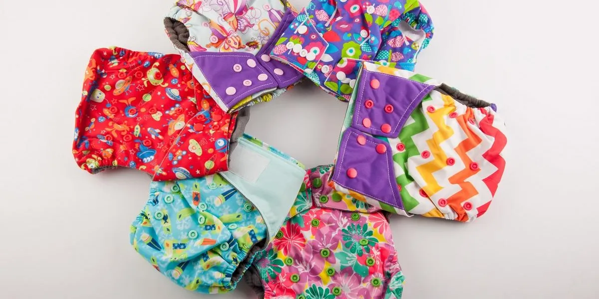 colorful children cotton diapers with pattern and buttons lay on white background colorful children cotton diapers with pattern and buttons lay on white background