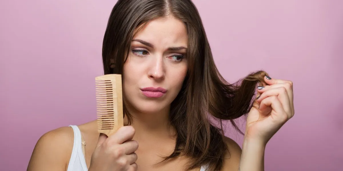 femme se brosser les cheveux avec un peigne en bois