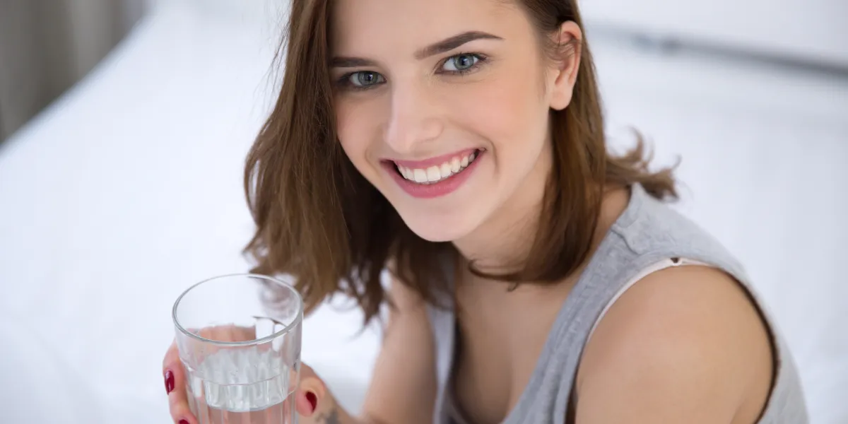 portrait d'une femme souriante tenant le verre d'eau portrait d'une femme souriante tenant le verre d'eau