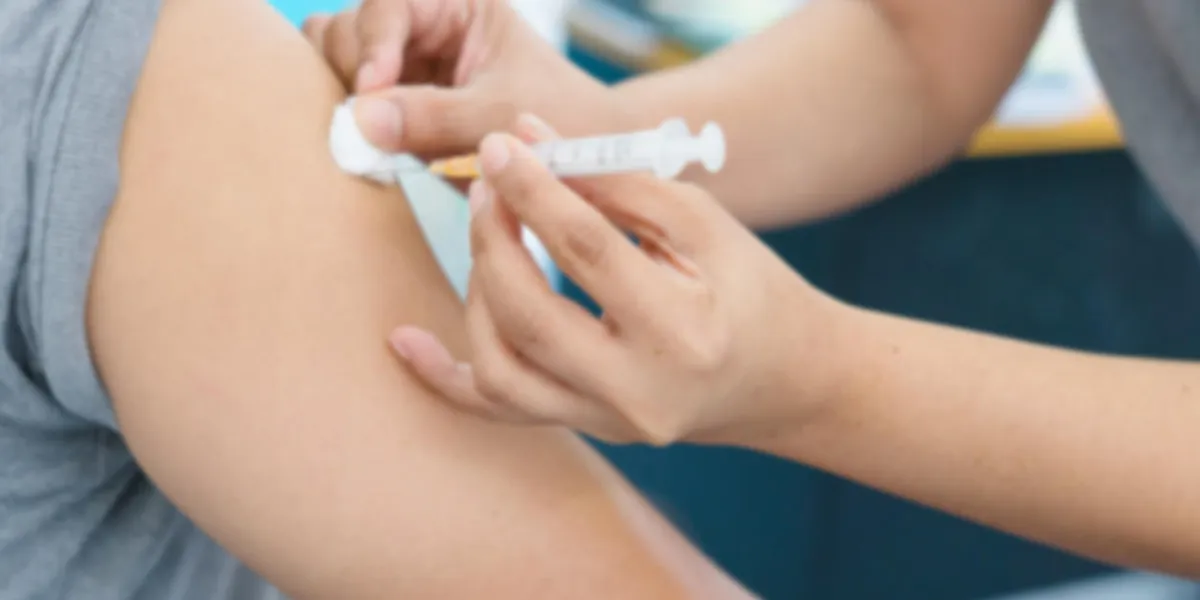 blurry background of nurse are vaccinations to patient to prevent diseases that are prevalent closed-up of hand with vaccine shot blurry background of nurse are vaccinations to patient to prevent diseases that are prevalent closed-up of hand with vaccine shot