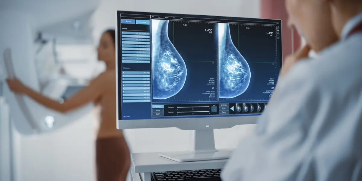 computer screen in hospital radiology room beautiful multiethnic adult woman standing topless undergoing mammography screening procedure screen showing the mammogram scans of dense breast tissues computer screen in hospital radiology room beautiful multiethnic adult woman standing topless undergoing mammography screening procedure screen showing the mammogram scans of dense breast tissues