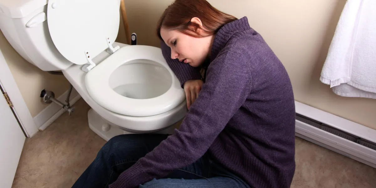 young woman slumped over toilet bowl