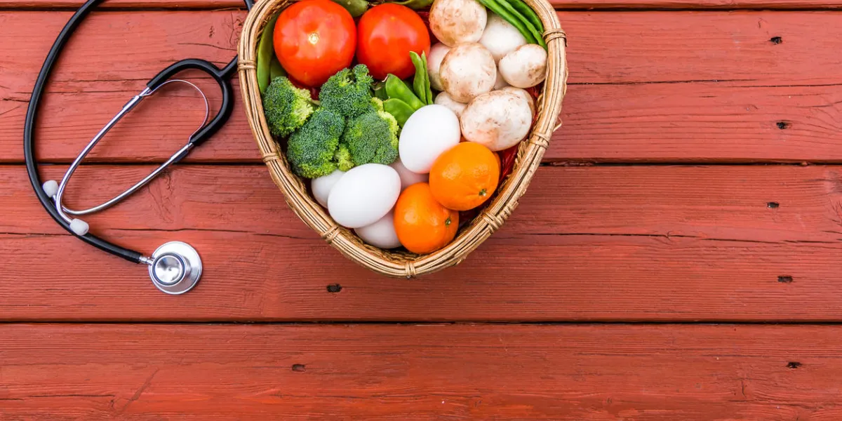 fresh vegetables and fruit in a heart shape basket on a old red wood table