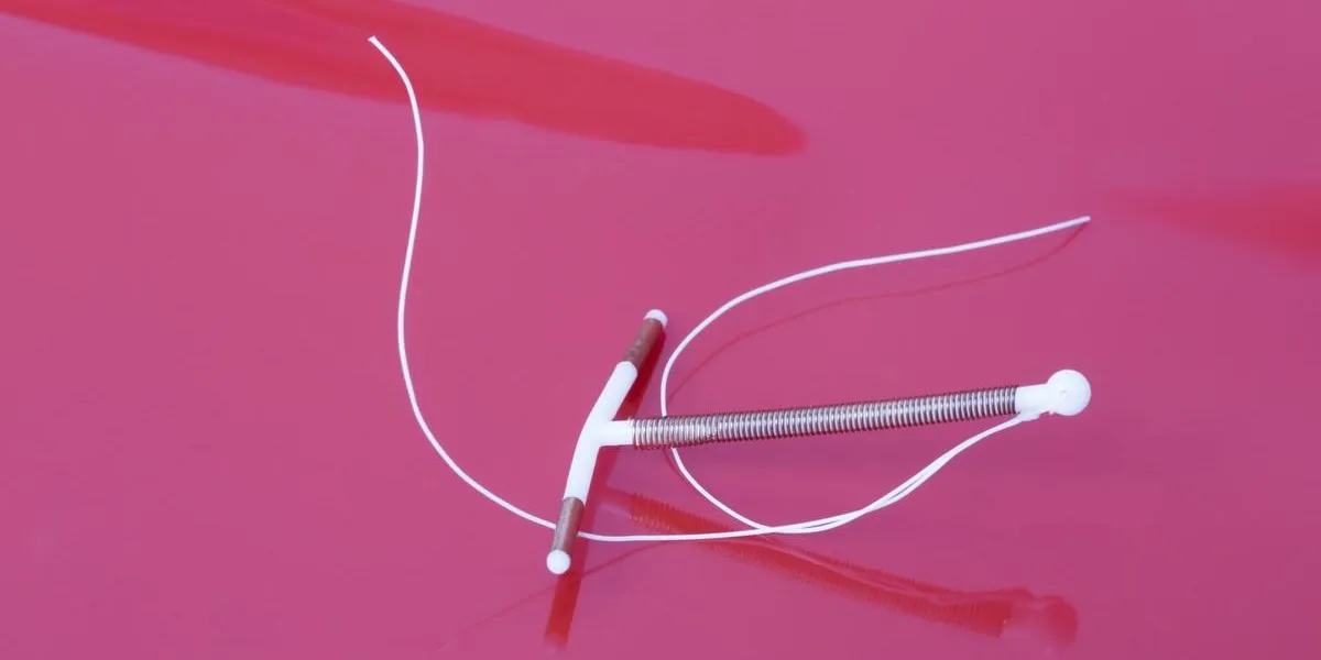 intrauterine device with copper on red background intrauterine device with copper on red background
