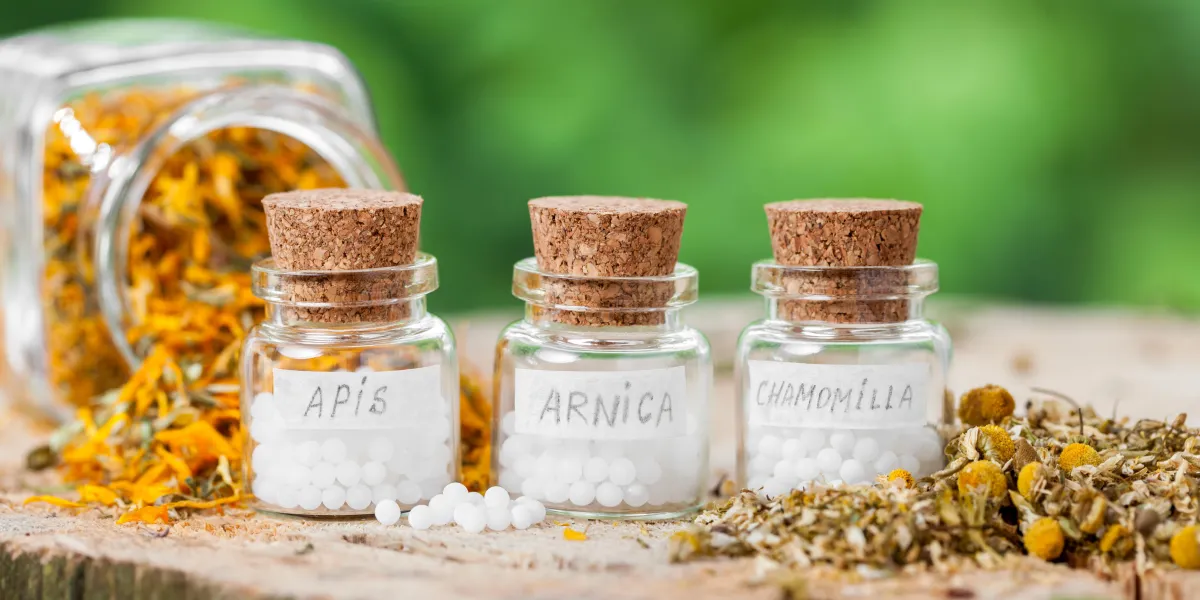 trois bouteilles de globules homéopathiques et d'herbes saines