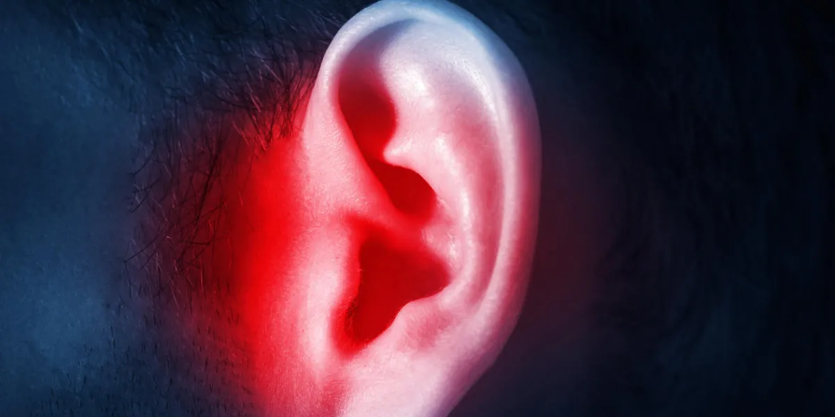 oreille masculine humaine sur un fond sombre isolé