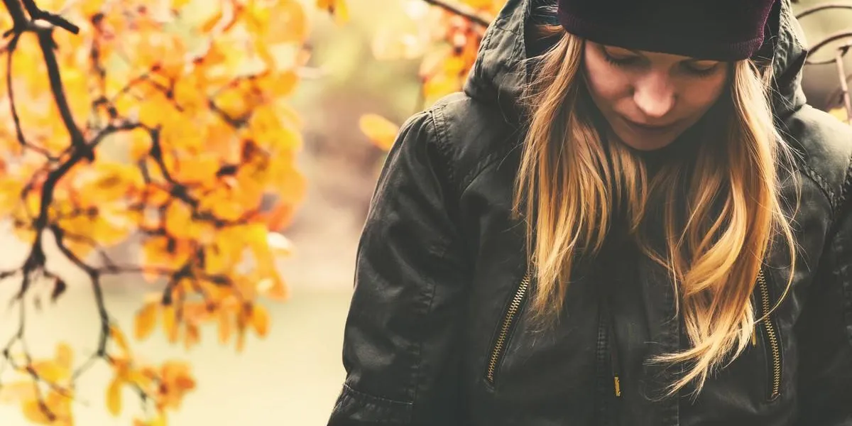 sad woman walking in park with autumn leaves on background outdoor seasonal melancholy lifestyle concept sad woman walking in park with autumn leaves on background outdoor seasonal melancholy lifestyle concept