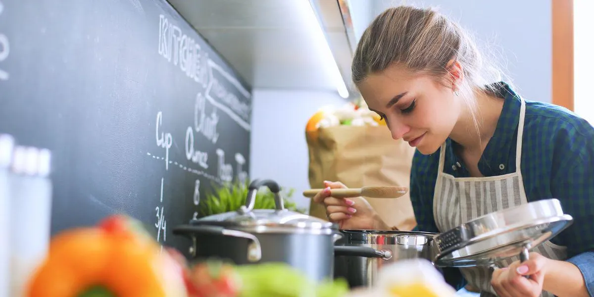 jeune femme debout près du poêle dans la cuisine