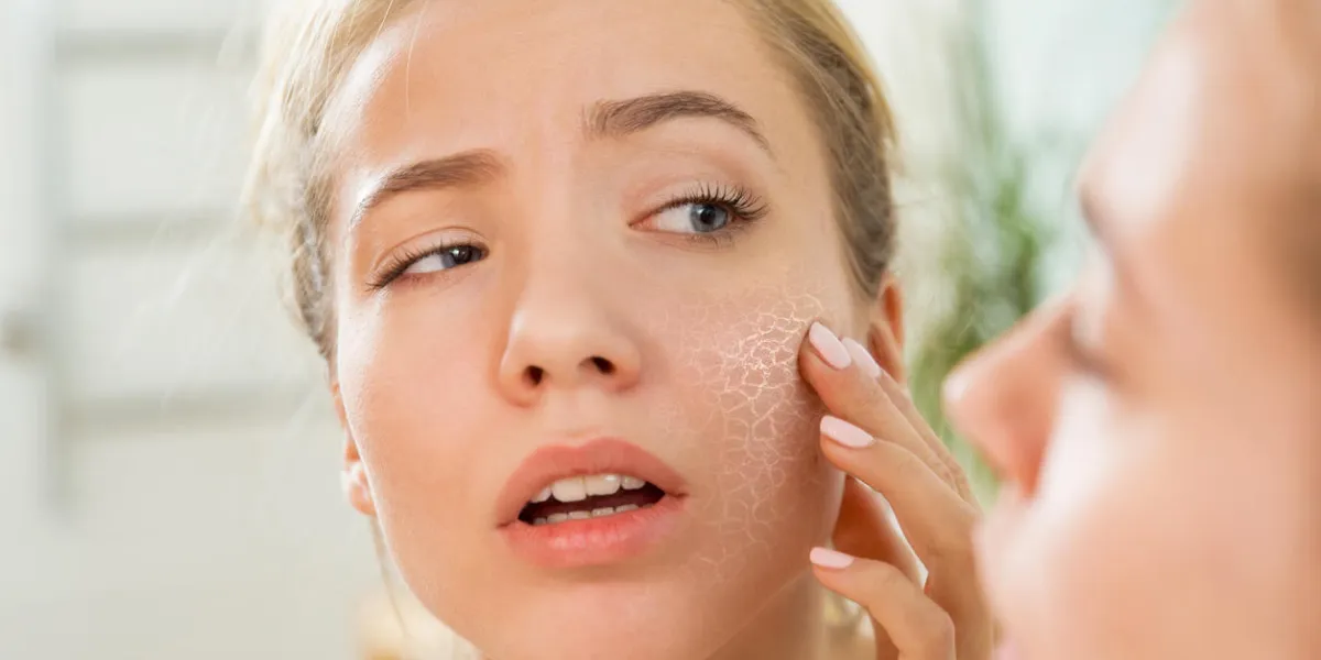 young beautiful woman touching skin in bathroom unhappy girl standing in towel, looking in the mirror, checking dry irritated skin morning skincare routine