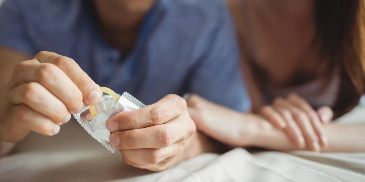 close-up of couple with a condom on bed in the bedroom close-up of couple with a condom on bed in the bedroom