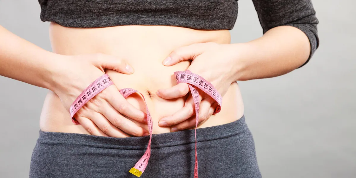 getting rid of belly fat, diet, weight loss or gain concept woman touching stomach holding measuring tape getting rid of belly fat, diet, weight loss or gain concept woman touching stomach holding measuring tape