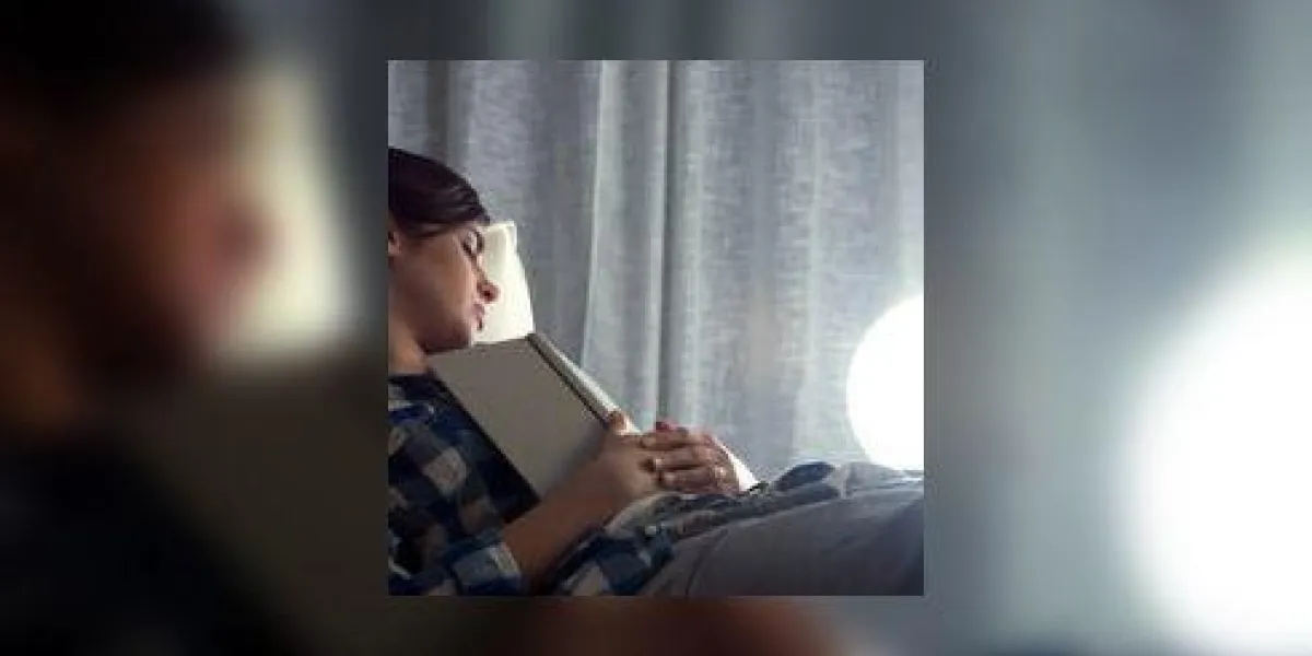 séduisante jeune femme allongée sur le canapé tenant un livre ouvert sur sa poitrine séduisante jeune femme allongée sur le canapé tenant un livre ouvert sur sa poitrine