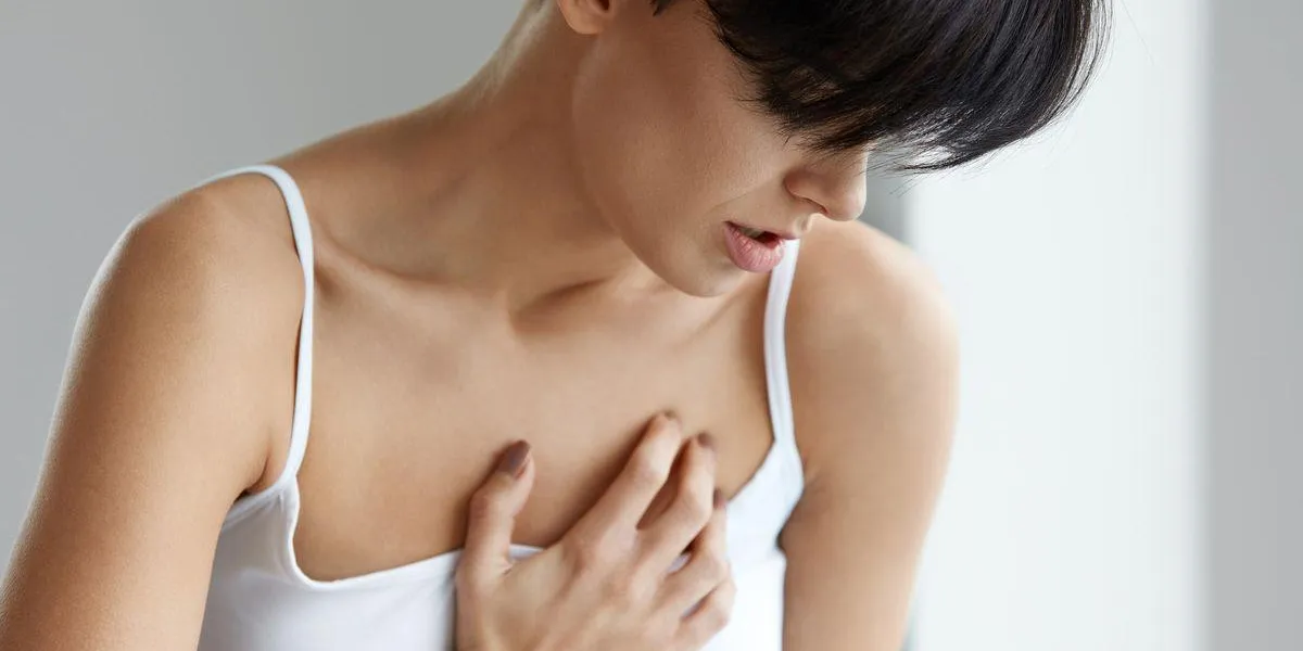 femme dans la douleur belle jeune femme sentiment forte forte douleur chez la fille de la poitrine souffrant de sensation de poumon douloureux ou ayant une crise cardiaque, tenant la main sur le concept de soins de santé de la poitrine haute résolution