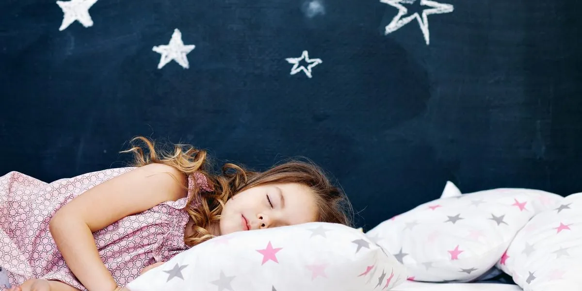 mignonne petite fille couchée dans le lit et dormir horizontal tir intérieur