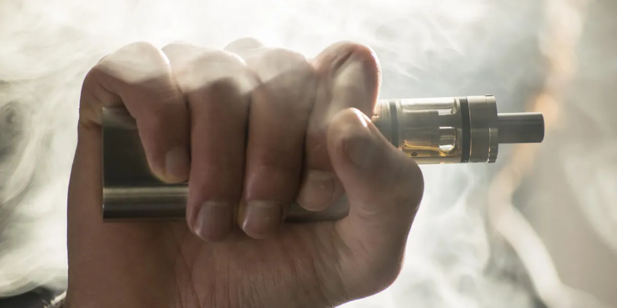 jeune homme vaping cigarette électronique, e cigarette, e cig avec des nuages de fumée