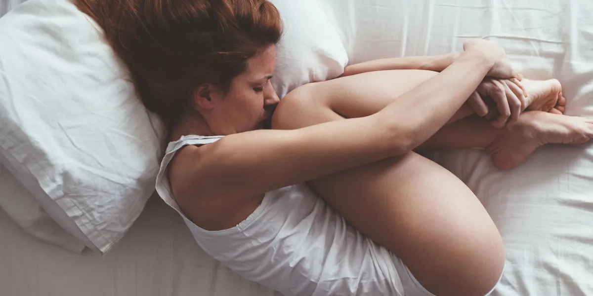 jeune femme couchée dans la position du fœtus