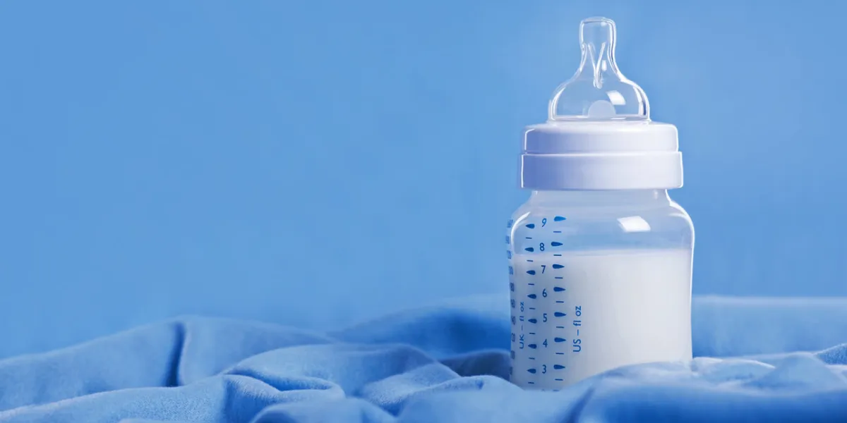 baby bottle with milk on a blue sheet baby bottle with milk on a blue sheet
