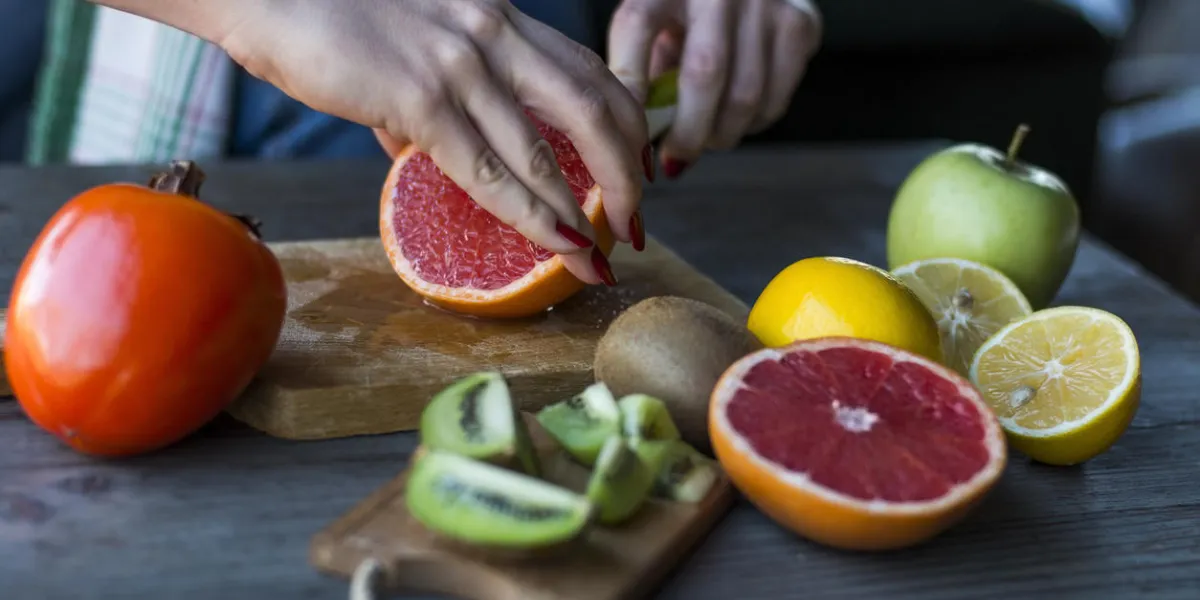 les mains coupent le pamplemousse frais les mains coupent le pamplemousse frais