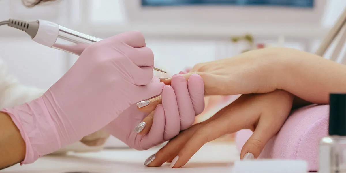 manicurist with a milling cutter for manicure