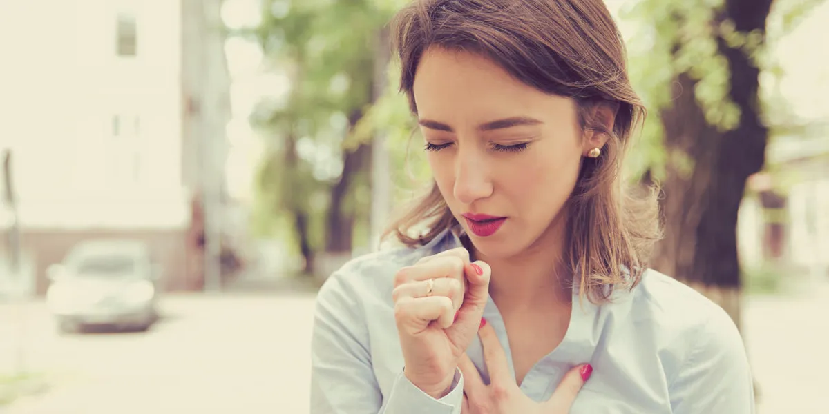 young woman having asthma attack or choking can't breath suffering from respiration problems standing outdoors on a urban street young woman having asthma attack or choking can't breath suffering from respiration problems standing outdoors on a urban street
