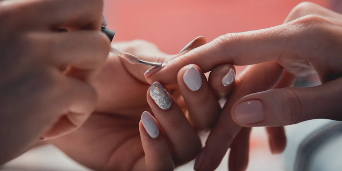 close up female hands painting nails while locating on table