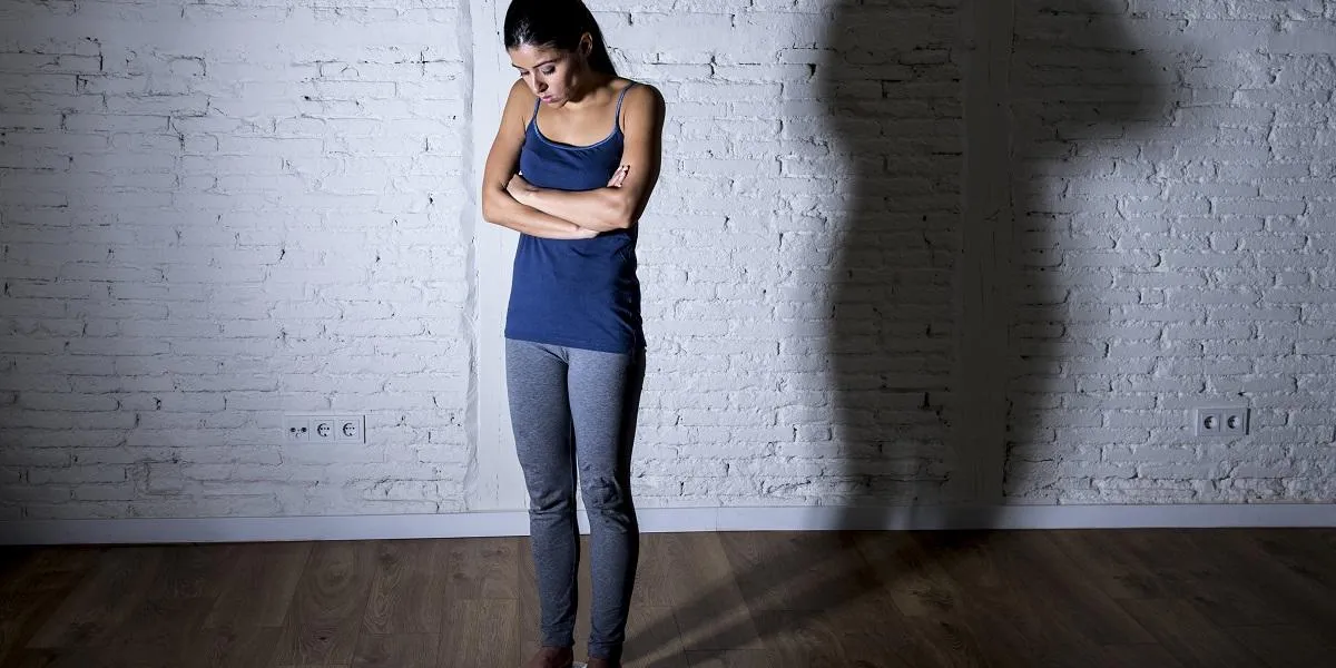 young fit slim woman or teen girl checking body weight on scale with big shadow light sad desperate and frustrated obsessed with overweight in anorexia and bulimia nutrition disorder young fit slim woman or teen girl checking body weight on scale with big shadow light sad desperate and frustrated obsessed with overweight in anorexia and bulimia nutrition disorder