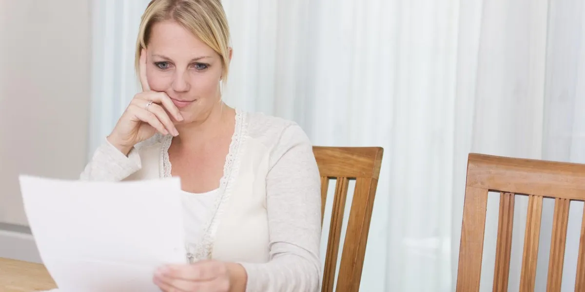 woman reading letter or doing finance paperwork going through home finances