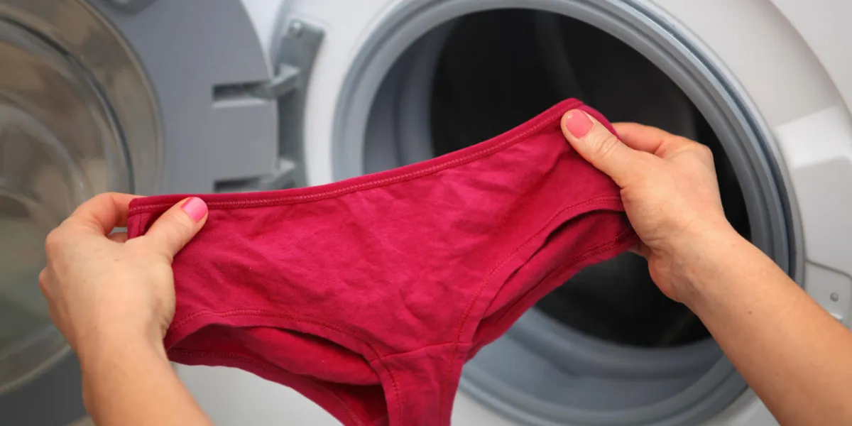 women's shorts in hands of woman who is going to do laundry it in washing machine