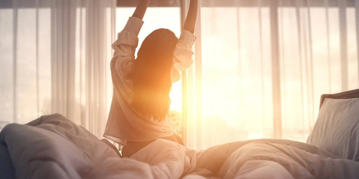 happy woman stretching in bed after waking up happy young girl greets good day