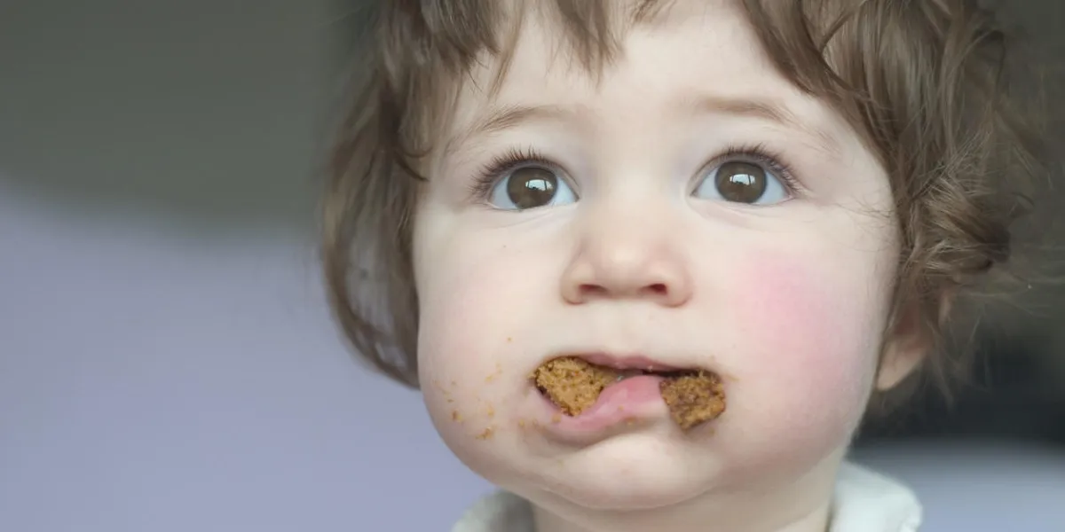 a little girl with her mouth full