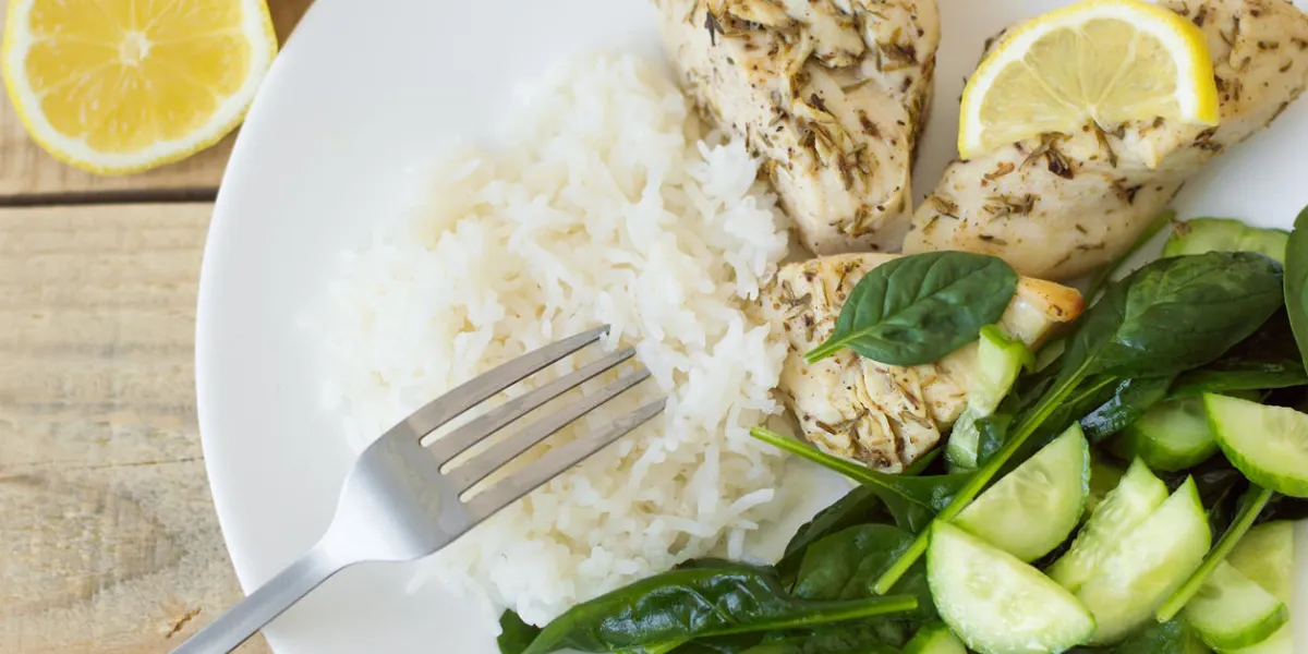 poitrines de poulet cuites au four avec citron, riz blanc et épinards verts et salade de concombre