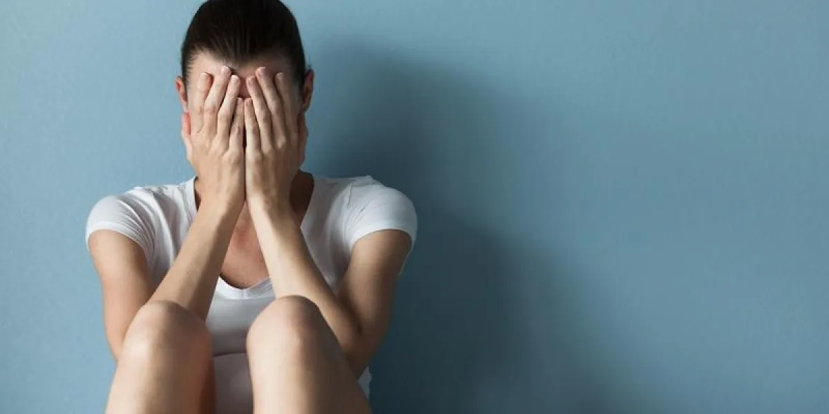 depressed young woman sitting alone in the room