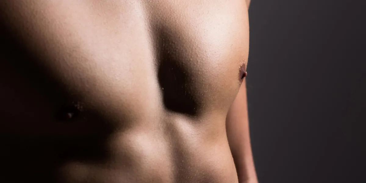 close up of a sports man's chest muscular man on a dark background