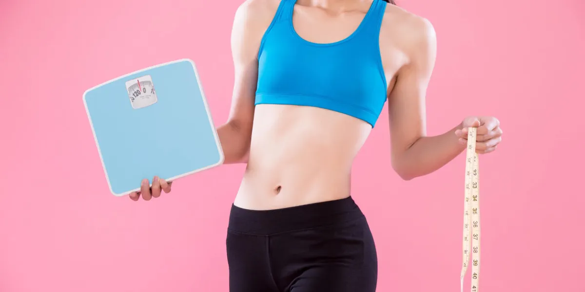 sport woman take weight and waist scale on the pink background sport woman take weight and waist scale on the pink background