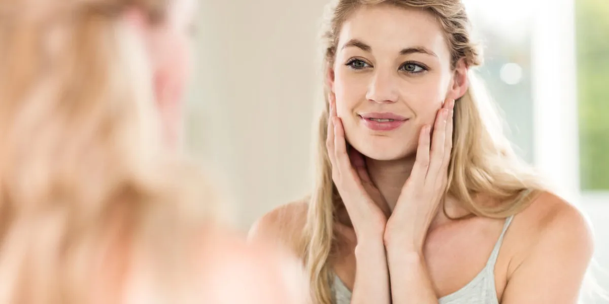 happy young woman looking in mirror at home happy young woman looking in mirror at home