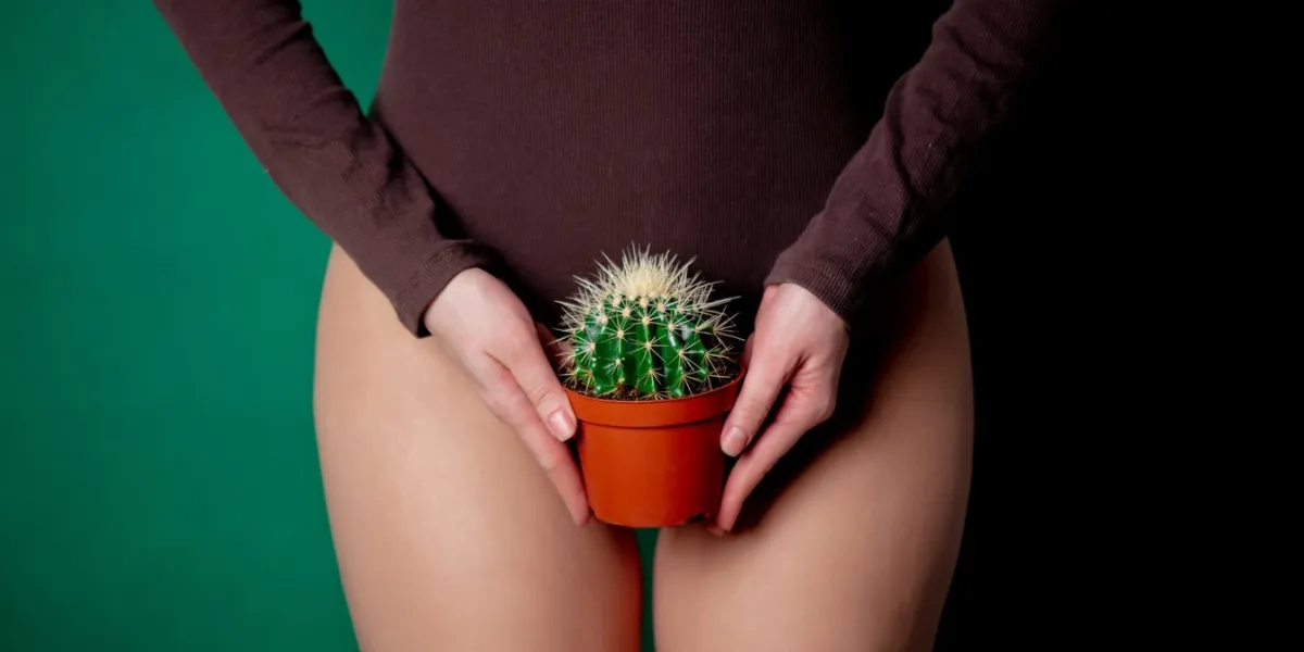 woman holds cactus in her hands at foot level