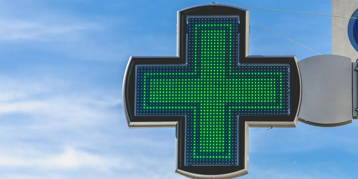 green cross of pharmacy electronics on blue sky