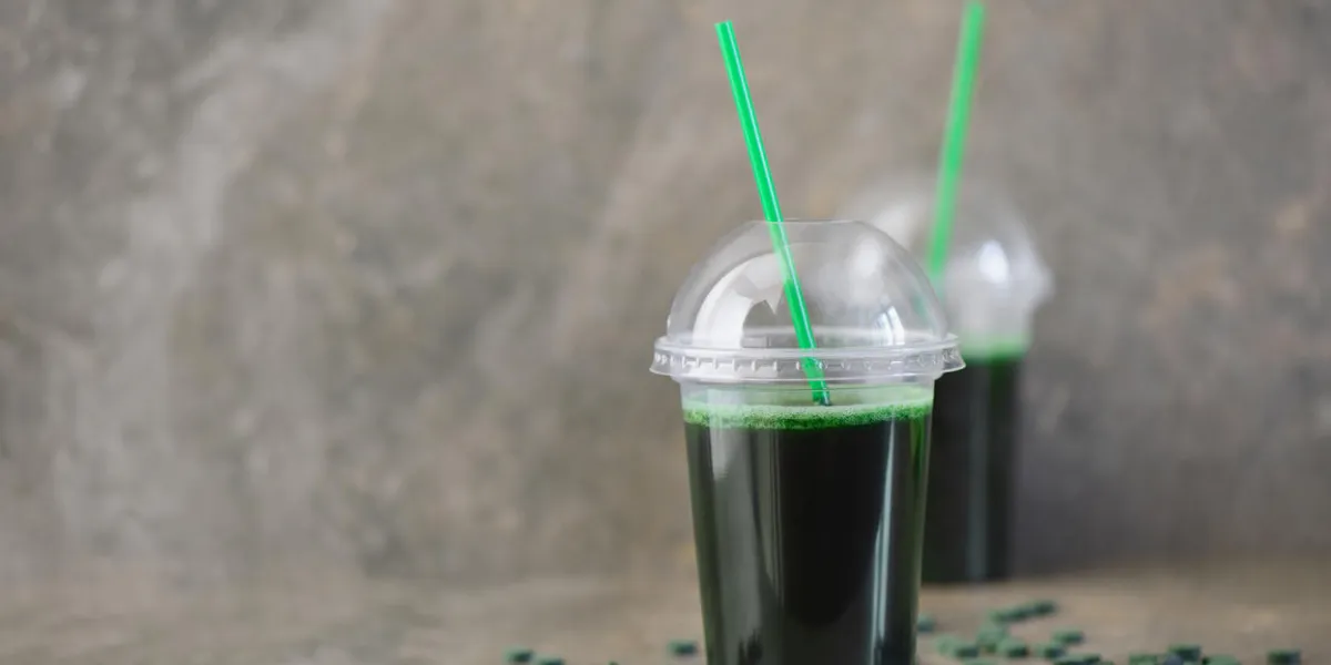 spirulina drink in two glasses, front view, space for a text