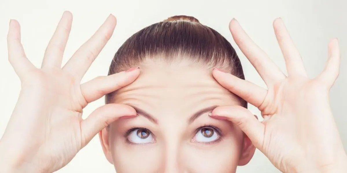 portrait of a young woman with wrinkles on his forehead on white background portrait of a young woman with wrinkles on his forehead on white background