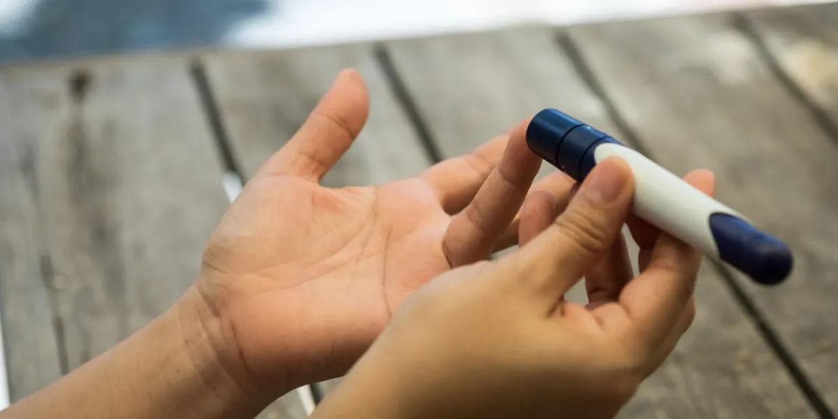 close up of woman hands using lancet on finger to check blood sugar level by glucose meter using as medicine, diabetes, glycemia, health care and people concept close up of woman hands using lancet on finger to check blood sugar level by glucose meter using as medicine, diabetes, glycemia, health care and people concept