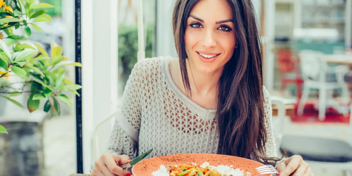 young woman eating chinese food in a restaurant, having her lunch break close up