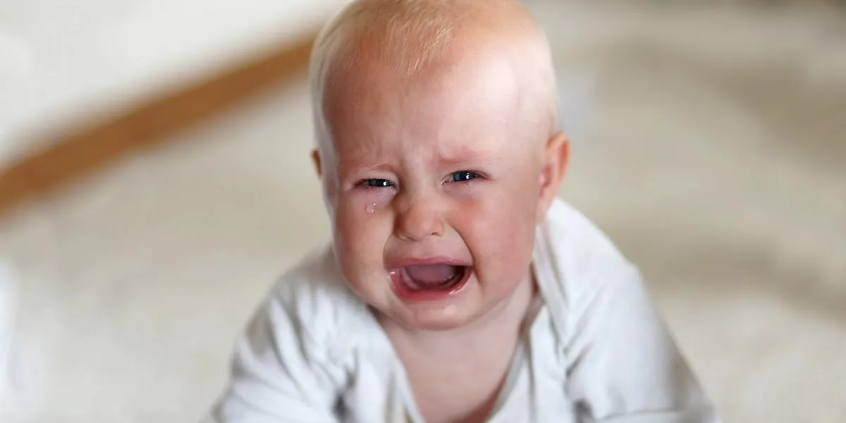 une petite fille mignonne mais triste de 6 mois pleure en regardant la caméra dans sa maison